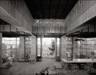 A black and white photo of a living room with a view.