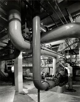 A black and white photo of pipes in an industrial setting.