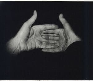 A black and white photograph of two hands reaching out.