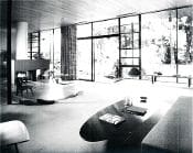 A black and white photo of a living room with a large window.