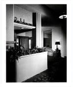 A black and white photo of a room with plants.