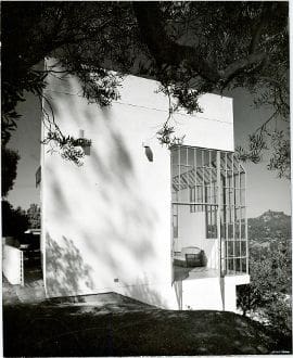 An old black and white photo of a house on a hill.