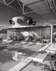 A black and white photo of an indoor swimming pool.