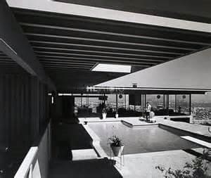 A black and white photo of a house with a pool.