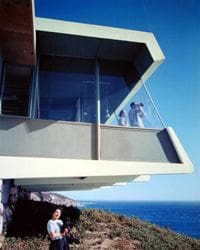 A house on a cliff overlooking the ocean.