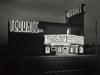 A black and white photograph of a theater at night.