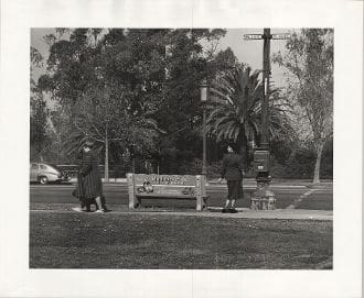 A black and white photo of people on the grass.