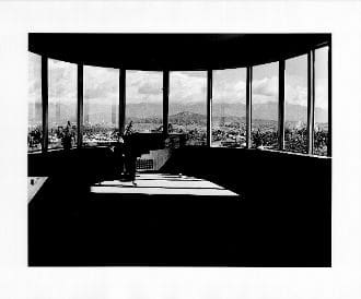 A black and white photo of a room with large windows.