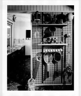 A kitchen with a wall of shelves and pots.