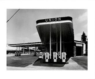 A black and white photo of an old gas station.