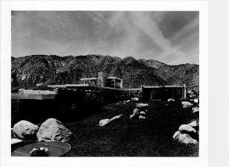 A black and white photo of some buildings in the desert.