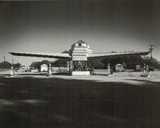 A black and white photo of an airplane in the middle of nowhere.