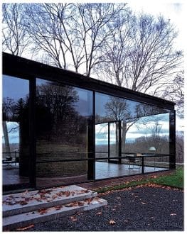 A black building with glass windows and trees in the background.