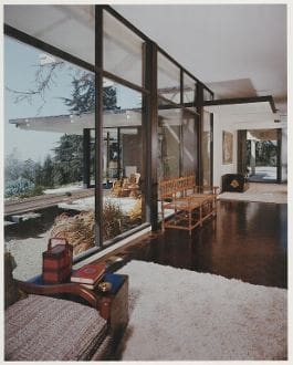 A living room with large windows and wooden floors.