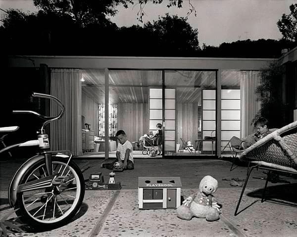A black and white photo of people in the backyard.