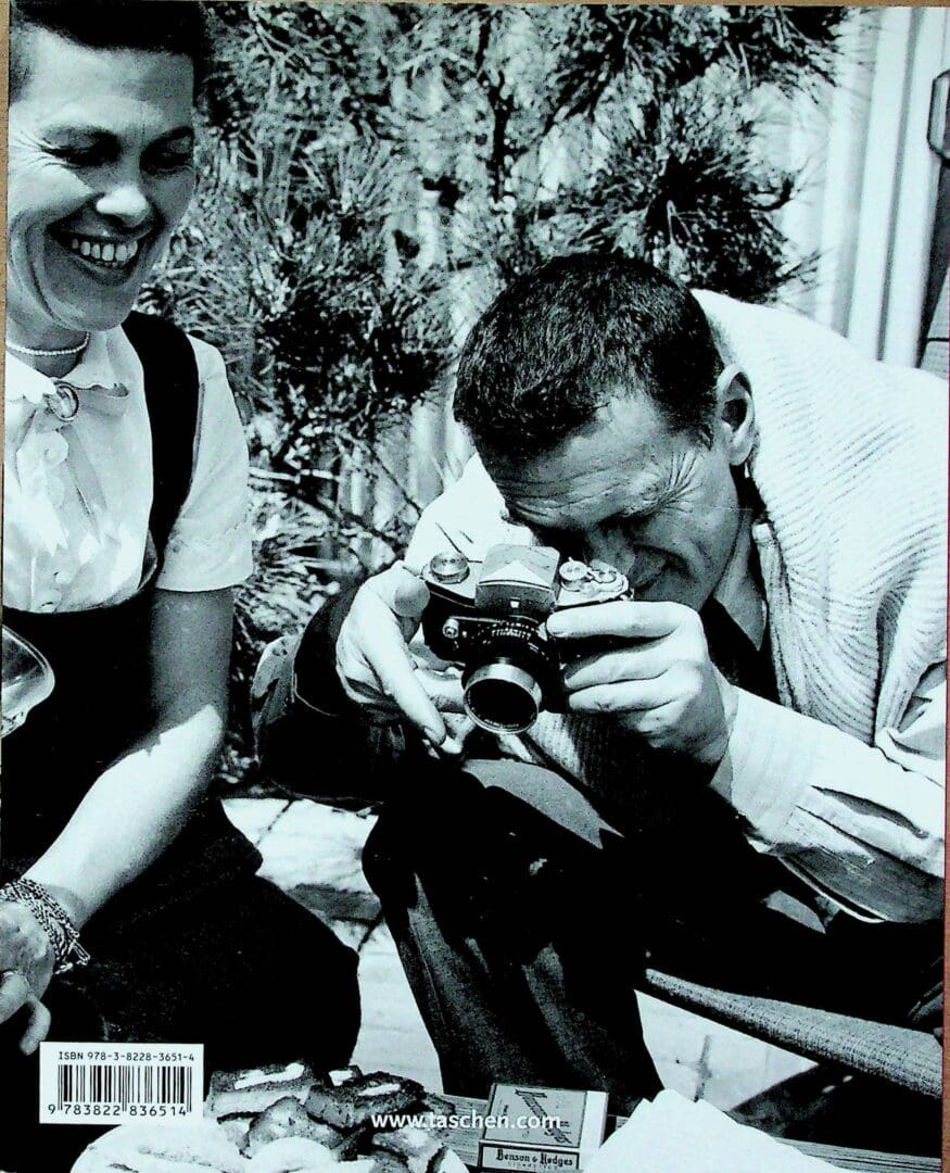 Man aiming vintage camera while woman smiling