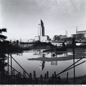 Historic skyline reflected in calm water.