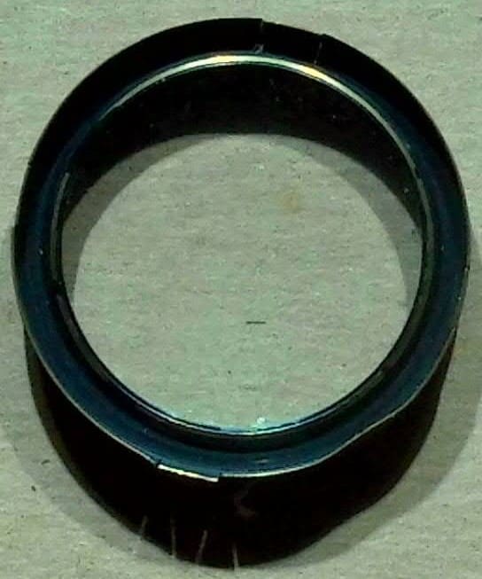 Close-up of a black ring on a light surface.