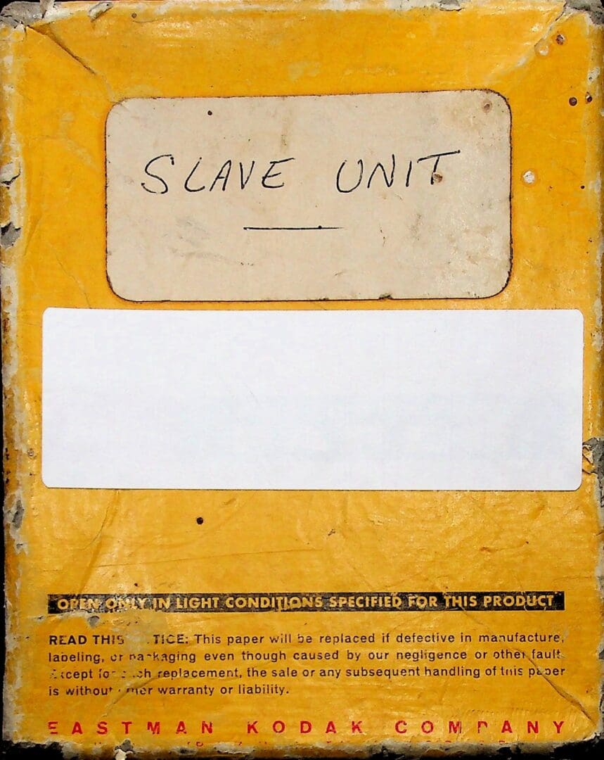 Close-up of a yellow device labeled 'Slave Unit' with a blank white label.