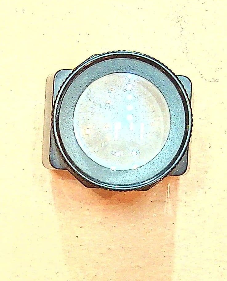Circular camera lens filter on beige background