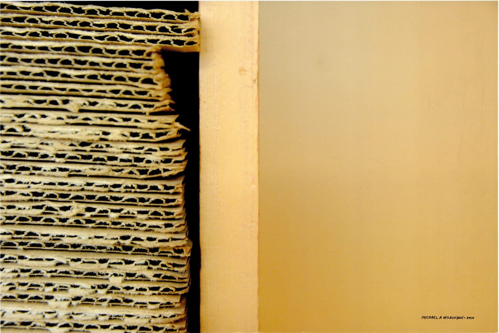 Stacked corrugated cardboard beside beige panel
