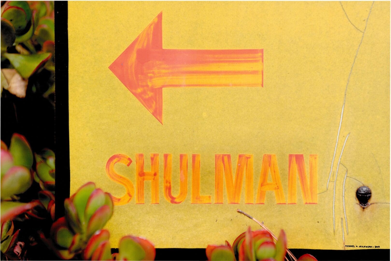 Yellow sign with left arrow reading "SHULMAN