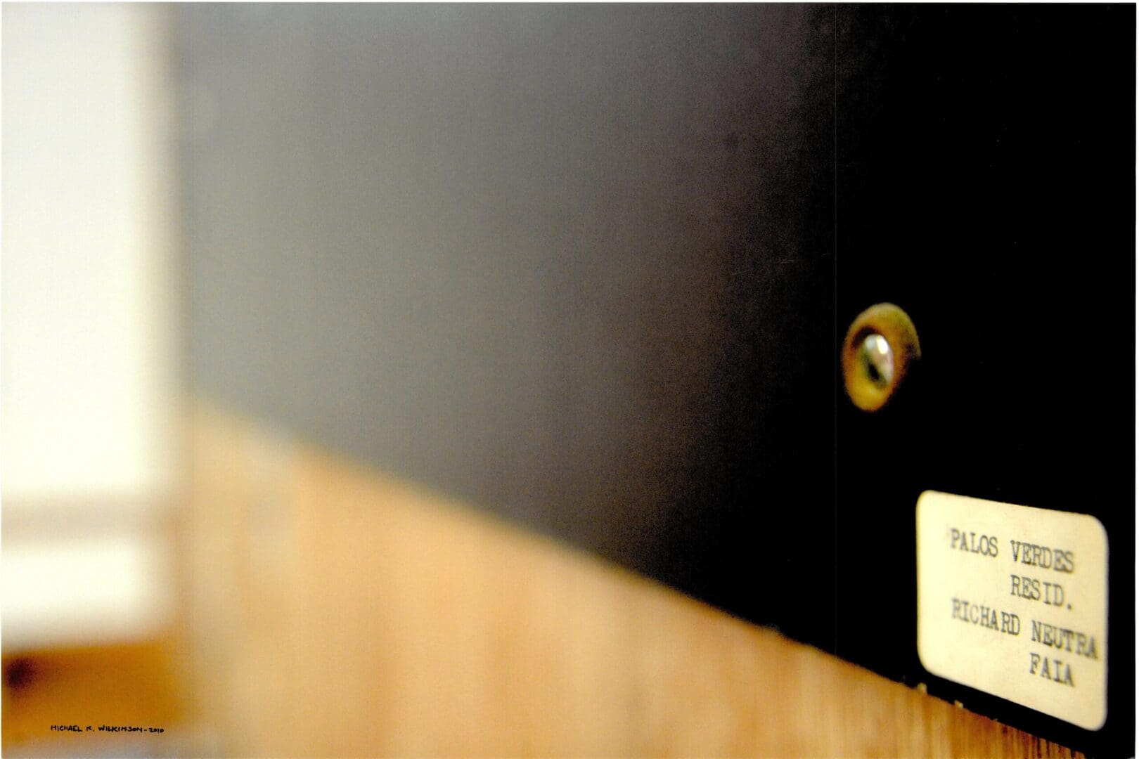 Close-up of door peephole and nameplate
