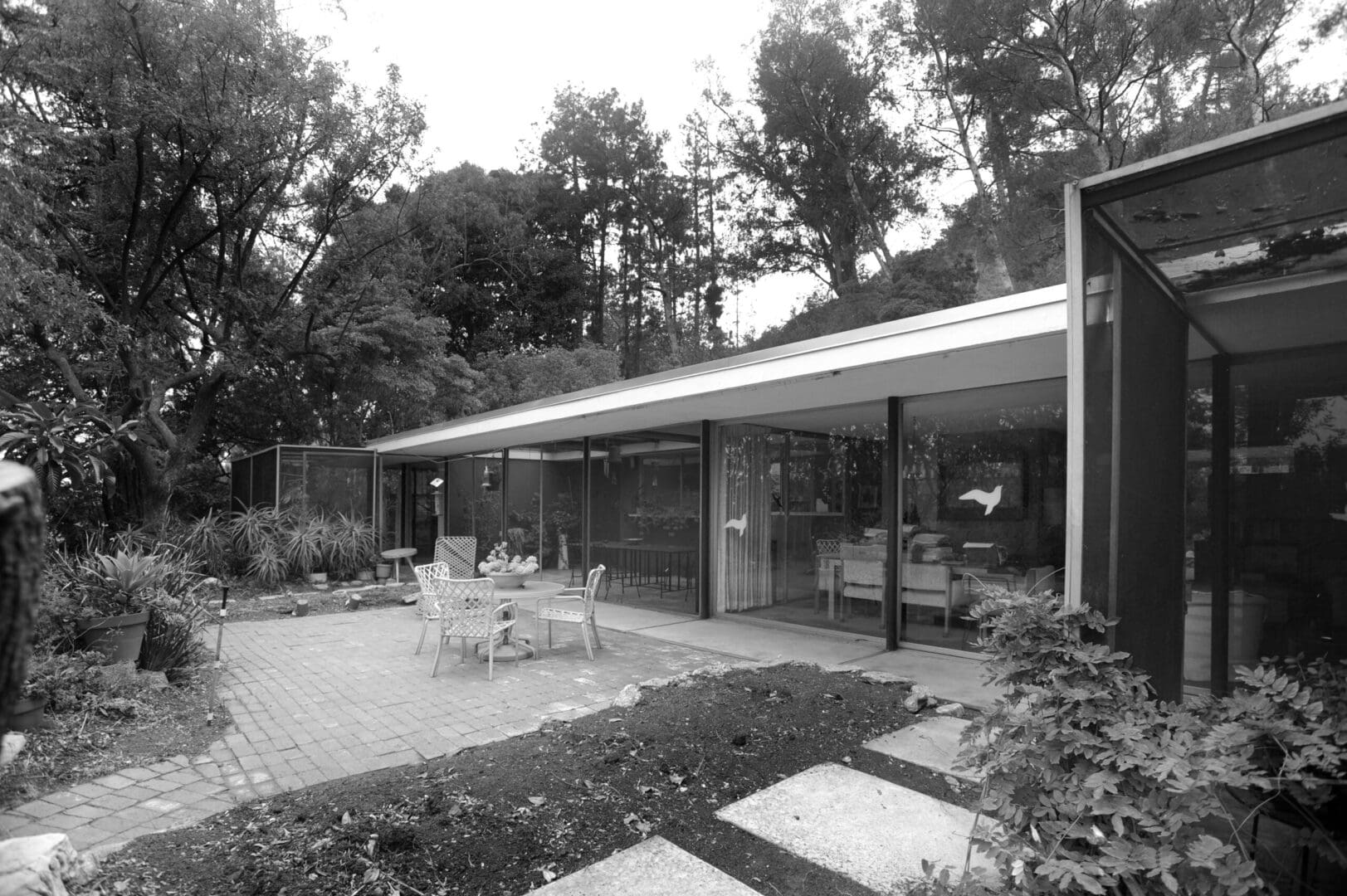 Glass-walled modern house patio with chairs