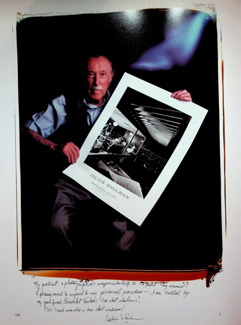Elderly man holding large black-and-white photograph