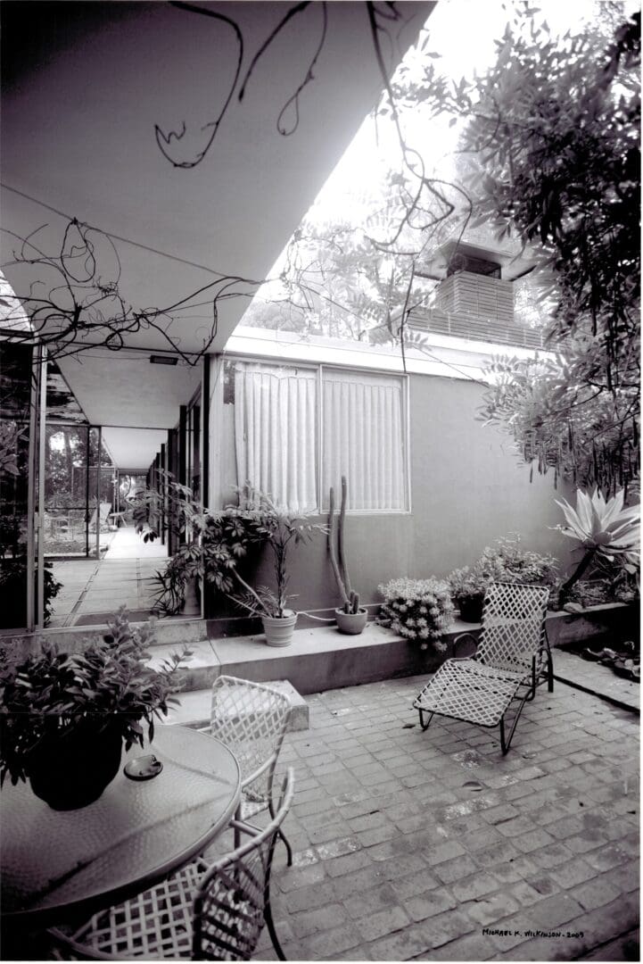 Shaded courtyard with metal chairs and potted plants